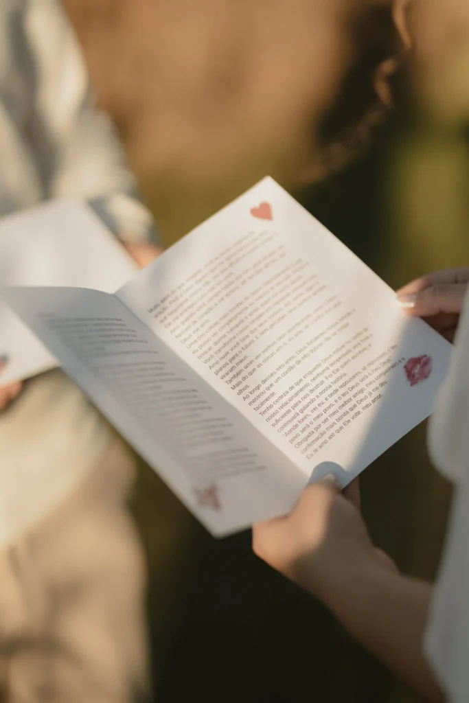 Wzruszona Para Młoda czytająca własną przysięgę małżeńską z eleganckiej karty podczas ceremonii ślubnej